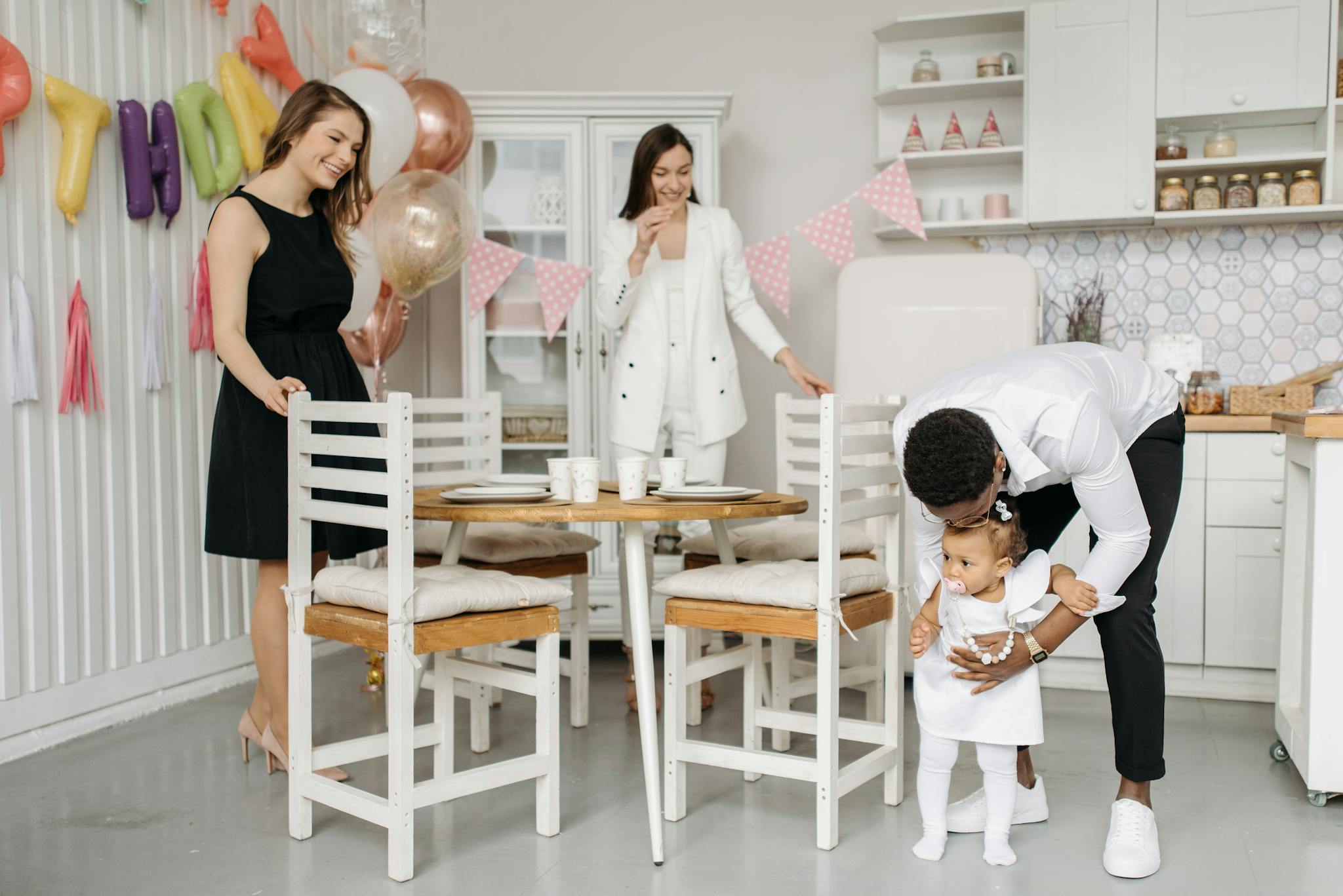 A joyful family birthday party in a modern kitchen with balloons and decorations.